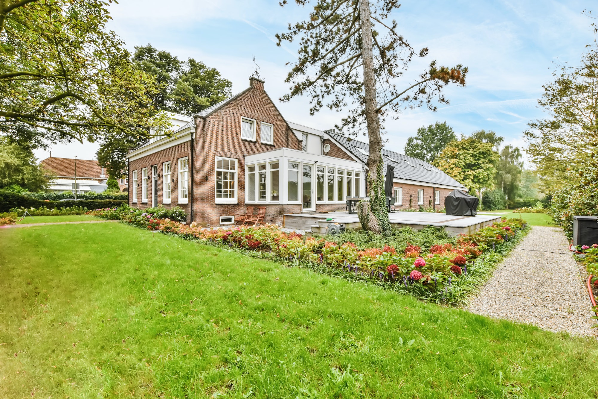 the facade of a one story brick house with a green fresh lawn